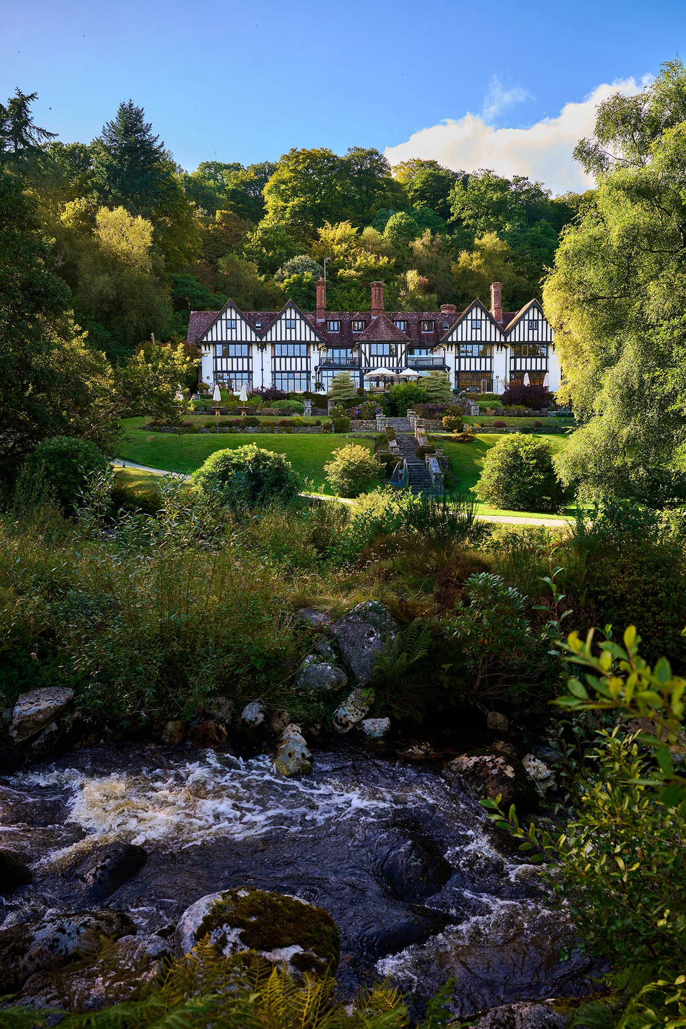 photo of Gidleigh Park on a sunny day with blue sky and river running in foreground